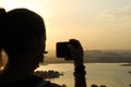 Young woman taking a picture of the beautiful sunset in Udaipur