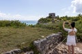 Young woman taking a picture of the Mayan ruin of Tulum in Yucatan Mexico, an ideal background with the Caribbean Sea and its Royalty Free Stock Photo