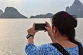 young woman taking pictures of the morning sea view with mobile phone Royalty Free Stock Photo