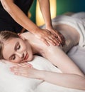 Young woman taking pleasure on massage bed, with eyes closed. Woman. Spa salon. Royalty Free Stock Photo