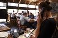 Young woman taking a reservation by phone at a restaurant