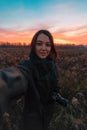 Young Woman Taking Selfie at Beautiful Sunset Backround. Concept Of Idyllic Landscape, Memorizing Of Inspiriting Moments