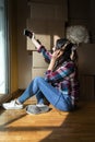 Young woman taking selfie with headphones next to pile of cardboard boxes.Vertical image Royalty Free Stock Photo