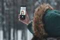 Young woman taking a selfie hiking a winter forest using his smartphone. Winter nature. Selfie. Selective focus Royalty Free Stock Photo