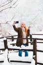 Young woman taking a selfie in a park in winter Royalty Free Stock Photo