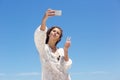 Young woman taking selfie with peace hand sign Royalty Free Stock Photo