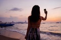 Young woman taking a selfie photo in sunset tropical beach sea view background with her mobile phone. Beautiful Asian Royalty Free Stock Photo