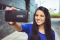 Young woman taking a selfie self-portrait photograph