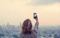 Young woman taking sunset photo