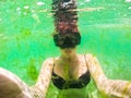 Young woman taking an underwater selfie wearing snorkeling mask when swimming and diving in the sea during algae blooms Royalty Free Stock Photo