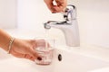 Young woman taking water direct from the tab to drink, showing its`s safety to drink tab water and cares for world environment to