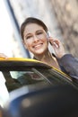 Young Woman Talking on Cell Phone By Yellow Taxi Royalty Free Stock Photo