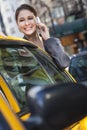 Young Woman Talking on Cell Phone By Yellow Taxi Royalty Free Stock Photo