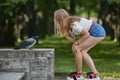 Young woman talks with crow outdoors
