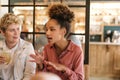 Young woman talking with friends over drinks in a cafe Royalty Free Stock Photo