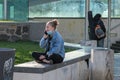 A young woman is talking on her phone close to Hradcanska tram stop during quarantine