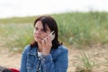 Young woman talking on mobile phone on the beach of the Baltic Sea Royalty Free Stock Photo