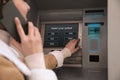 Young woman talking by mobile phone while using cash machine for money withdrawal outdoors, closeup Royalty Free Stock Photo