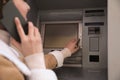 Young woman talking by mobile phone while using cash machine for money withdrawal outdoors, closeup Royalty Free Stock Photo