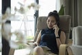 Woman talking on mobile phone and using digital tablet in living room. Royalty Free Stock Photo