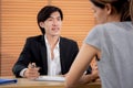 Young woman talking and negotiating about agreement and contract of document with consultant or agent at home office. Royalty Free Stock Photo