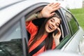 Young woman talking on the phone in the car and waving. Close up portrait of young business woman sitting in the car and laughing Royalty Free Stock Photo