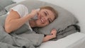 Young Woman Talking on phone while Lying on Side in Bed Royalty Free Stock Photo