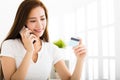 Young woman talking on the phone and showing credit card Royalty Free Stock Photo