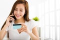 Young woman talking on the phone and showing credit card Royalty Free Stock Photo