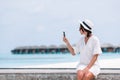 Young woman talking on phone during tropical beach vacation Royalty Free Stock Photo