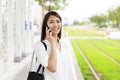 Young woman talking on the phone and waiting on the platform of a railway station for train Royalty Free Stock Photo