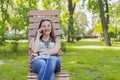 Young woman talking on the smartphone and laughing in the park on the bench Beautiful female relaxing on a park bench and using a Royalty Free Stock Photo