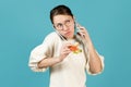 A young woman talking on two phones at once while eating Royalty Free Stock Photo