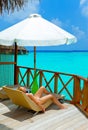 Young woman tans on villa on ocean Maldives Royalty Free Stock Photo