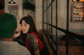 Young woman with tattoos talking with friends in a bar