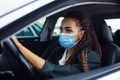 Young woman taxi driver sits in a car behind the steering wheel and driving during the covid-19 quarantine. Business trips during