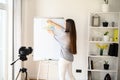 Young woman with flipchart records video lessons Royalty Free Stock Photo