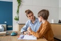 Young woman teacher tutor listening little boy pupil while giving private lesson Royalty Free Stock Photo