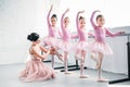 young woman teaching adorable children dancing in ballet