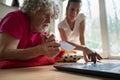 Young woman teaching a senior man how to use a laptop computer for online shopping and education Royalty Free Stock Photo