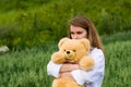 Sad young woman with teddy bear on nature Royalty Free Stock Photo