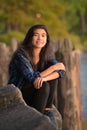 Young woman or teen sitting along lake pier at sunset Royalty Free Stock Photo