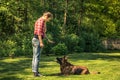 Young woman tell dog to lay down on grass,obedience training Royalty Free Stock Photo