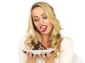 Young Woman Tempted into Eating Chocolate Cake Royalty Free Stock Photo