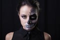 Young woman with terrifying make up posing on black background