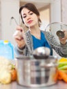 Young woman tests food with ladle