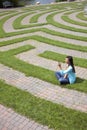 Young Woman Text Messaging in a Grass Maze Royalty Free Stock Photo