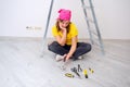 A young woman is thinking about repair questions laying out construction tools in front of her Royalty Free Stock Photo