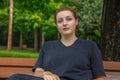 young woman thinking sitting on park bench outdoors student portrait Royalty Free Stock Photo