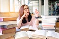 Young woman thinking while studying in library